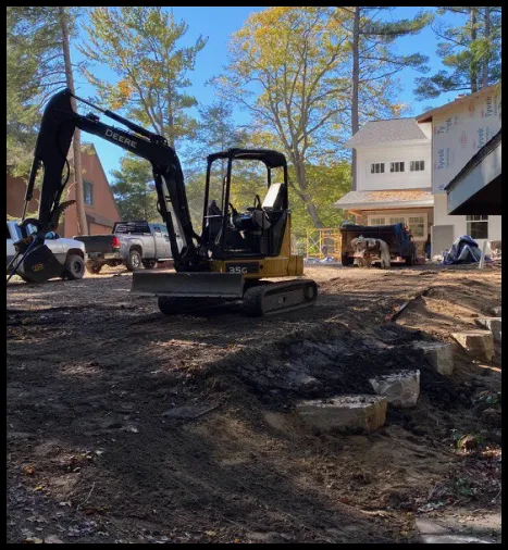 Excavator working on a driveway.